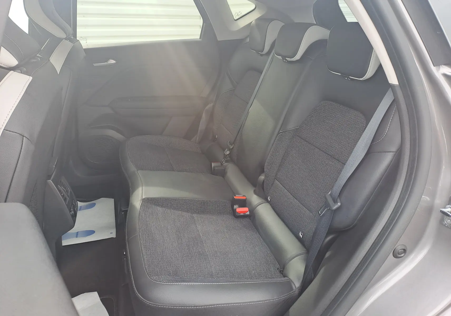 Vue intérieure côté droit des sièges arrière du Renault Captur 2022, sellerie tissu noir avec surpiqûres grises.