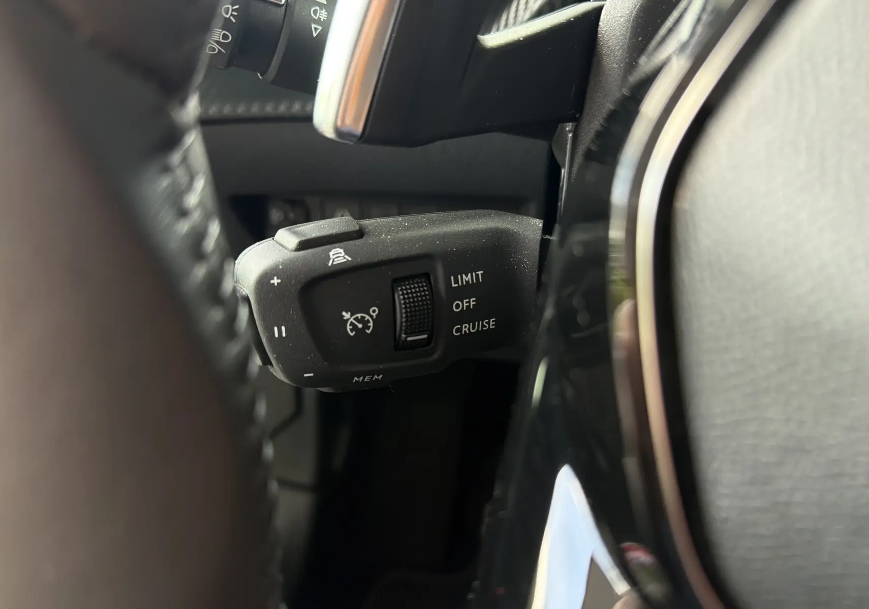 Gros plan sur la commande de régulateur de vitesse à gauche du volant du Peugeot 2008 gris Sellenium 2023.
