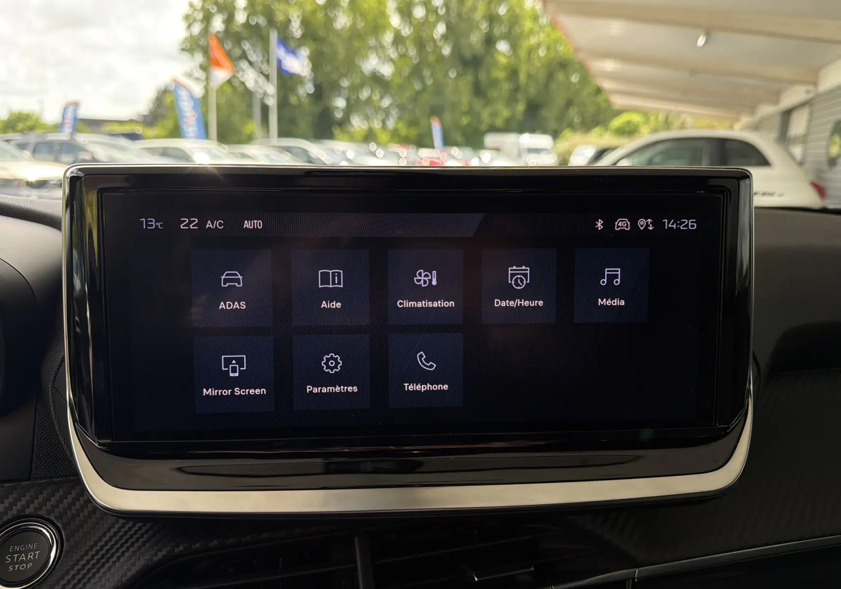 Vue intérieure centrée sur l'écran tactile du tableau de bord du Peugeot 2008 gris Sellenium, affichant les options de menu.