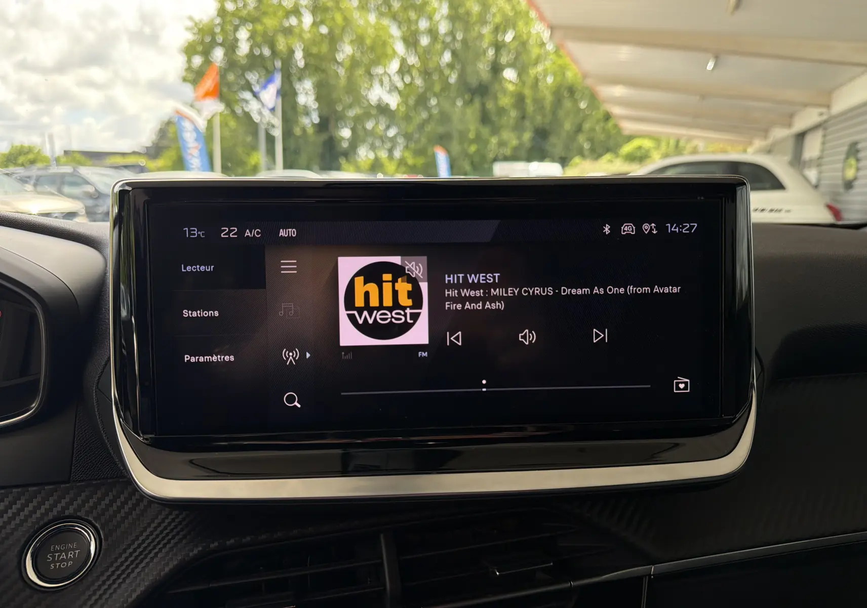 Écran tactile central du Peugeot 2008 1.2 130 EAT8 Allure affichant la radio Hit West, intérieur noir.
