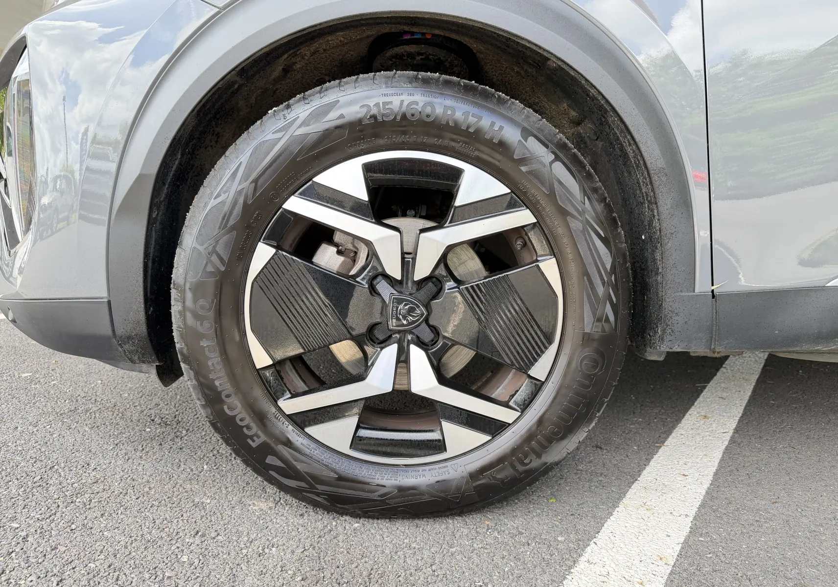 Gros plan sur la roue avant droite du Peugeot 2008 gris Sellenium, mettant en valeur la jante alliage 17 pouces bicolore.
