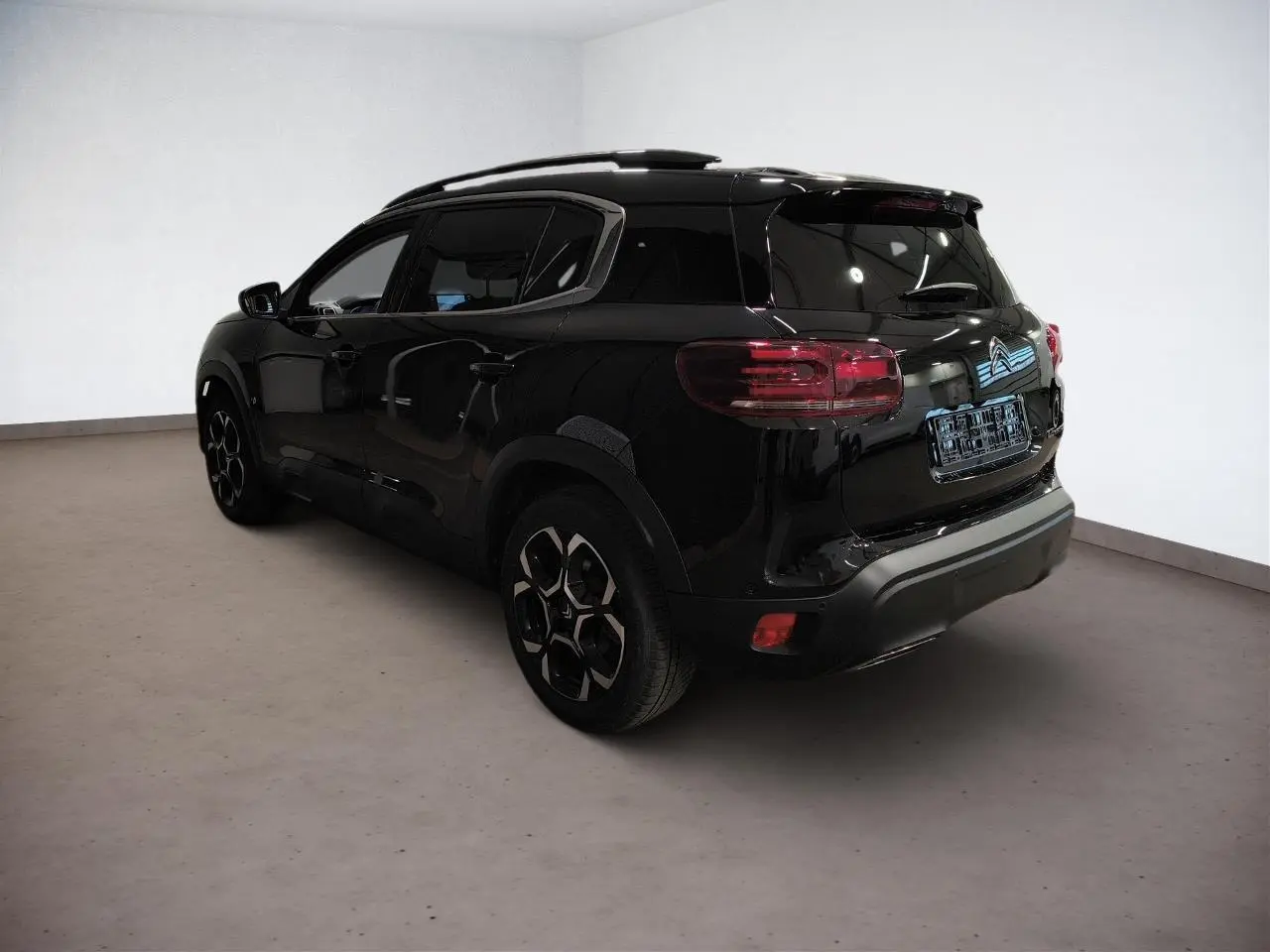 Vue 3/4 arrière droite d'un Citroën C5 Aircross noir Perla avec jantes alliage bi-ton et vitres surteintées.