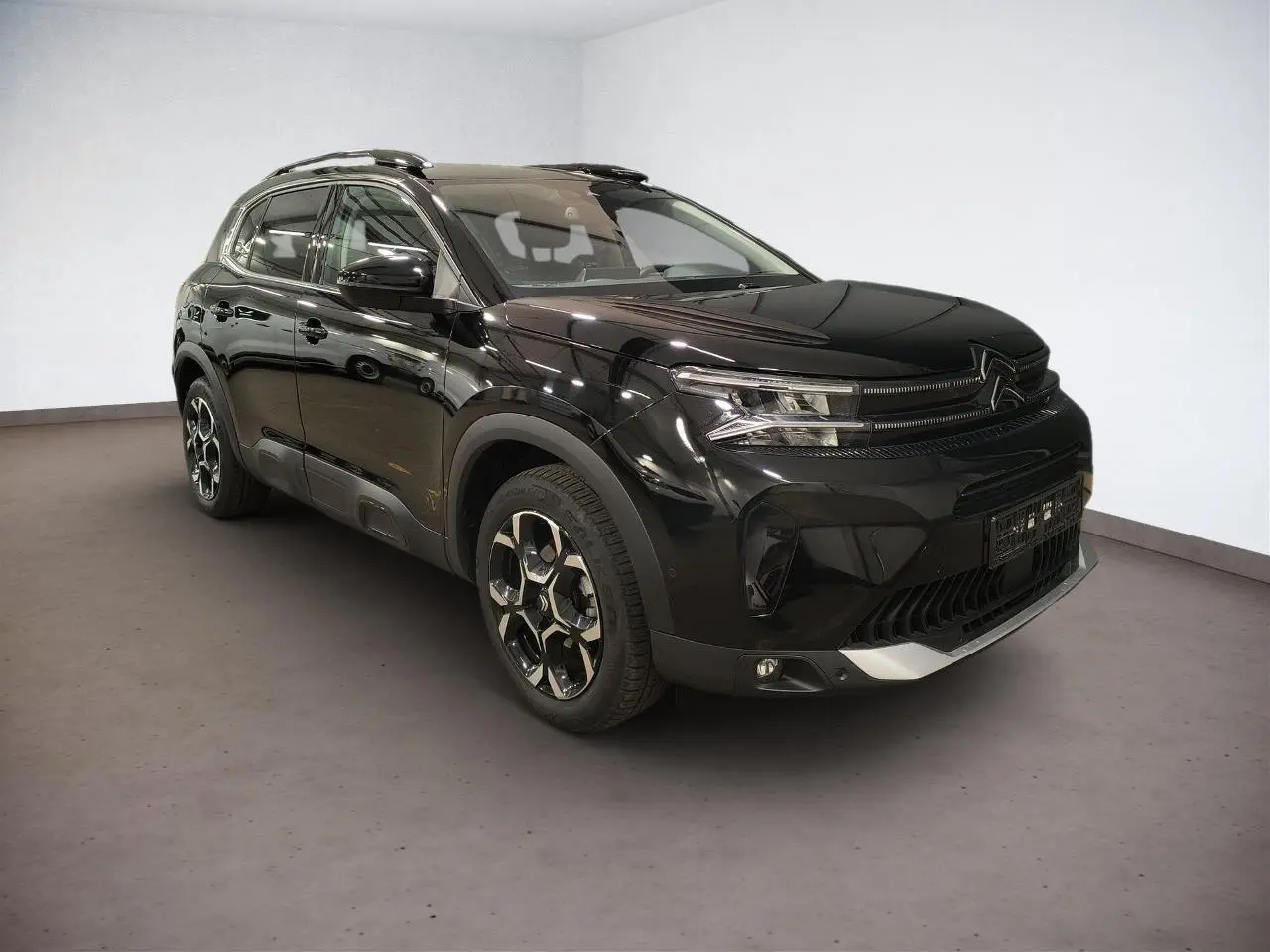 SUV Citroën C5 Aircross noir Perla en 3/4 avant droit, avec jantes alliage bi-ton et barres de toit noires.