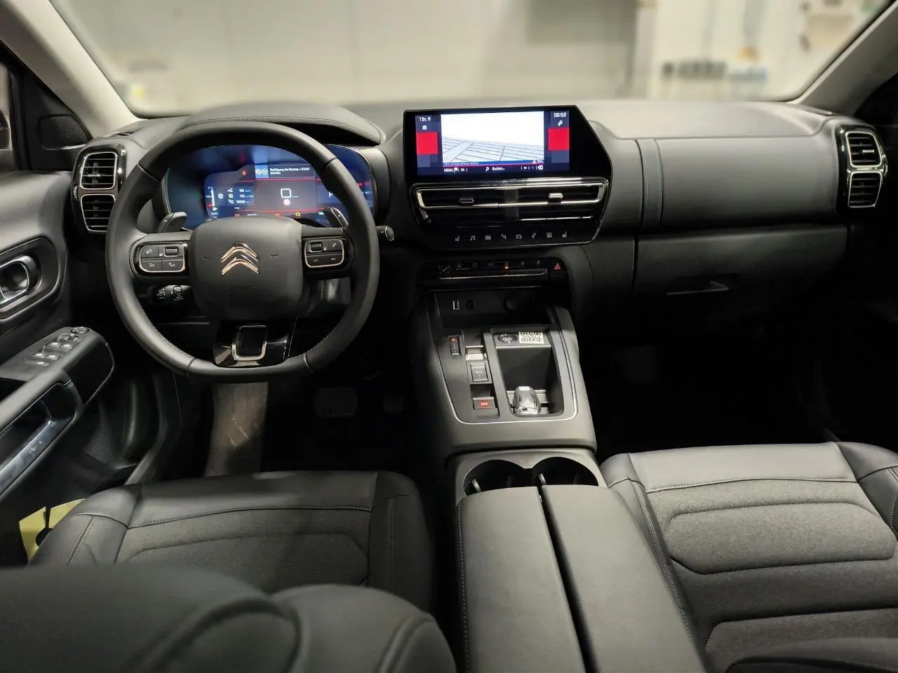 Vue intérieure avant du Citroën C5 Aircross 2025 noir Perla, avec tableau de bord numérique et écran tactile central.