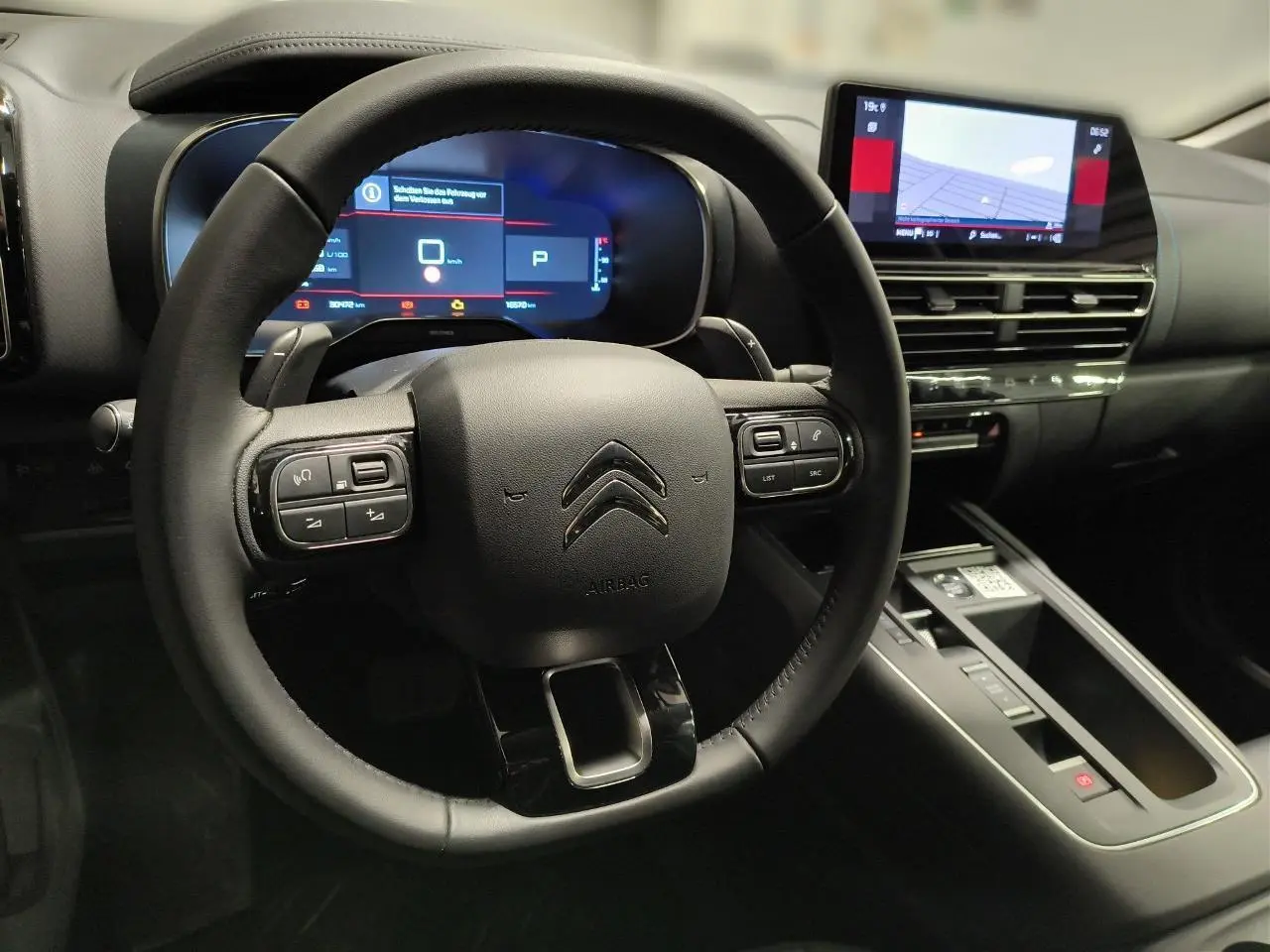 Vue rapprochée du volant noir et du tableau de bord numérique du Citroën C5 Aircross 2025 avec écran tactile central.