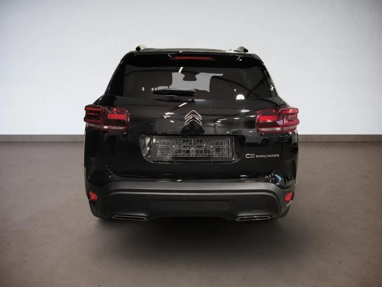 Vue arrière d'un Citroën C5 Aircross noir Perla avec feux arrière LED et double sortie d'échappement intégrée.