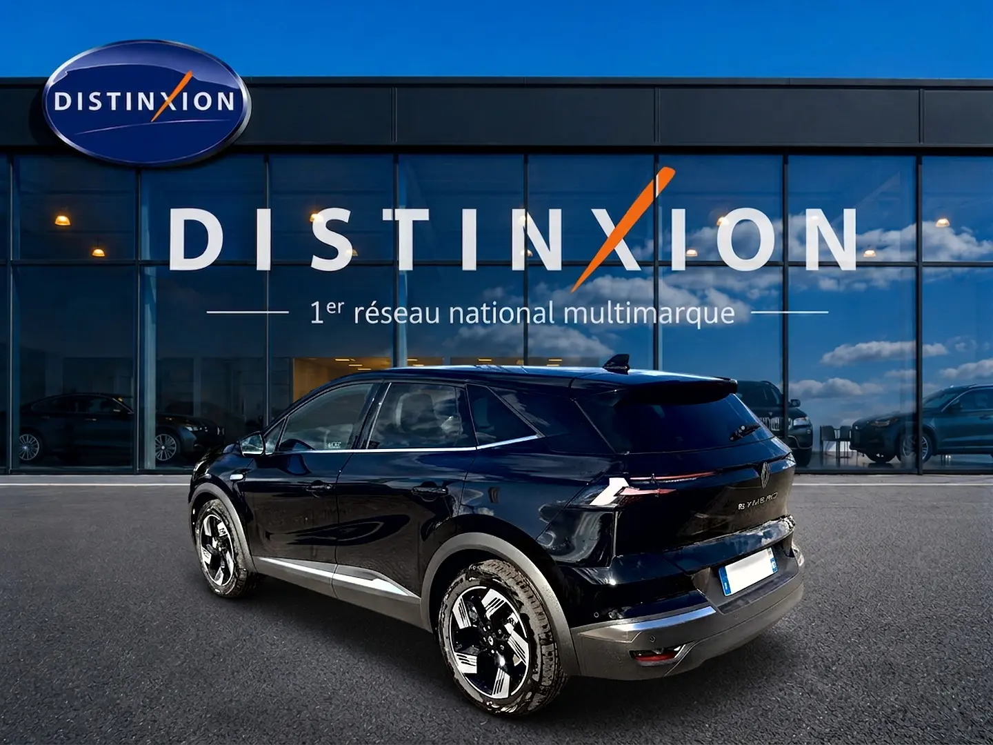 Vue 3/4 arrière droite du Renault Symbioz noir étoile avec jantes alu et feux arrière LED, devant une vitrine Distinxion.