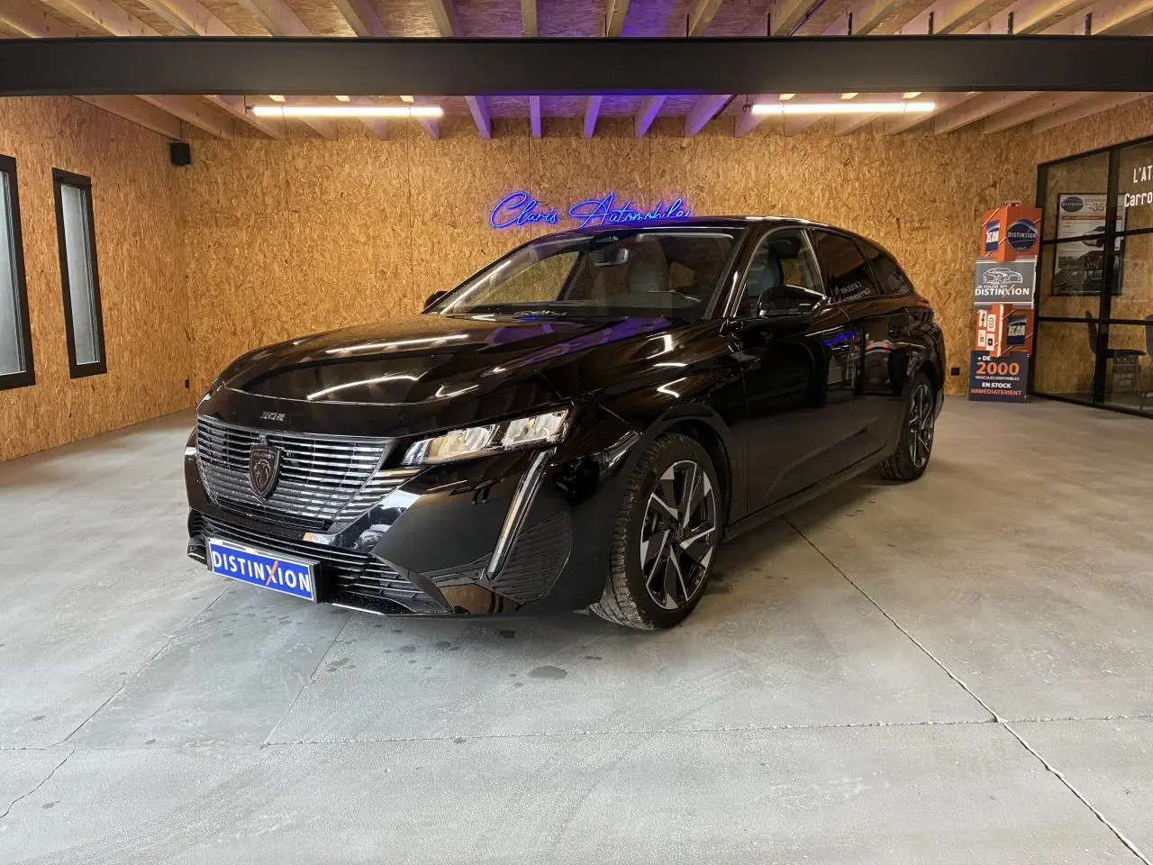 Peugeot 308 SW noire vue en 3/4 avant droit, avec calandre chromée et jantes alliage 17 pouces.