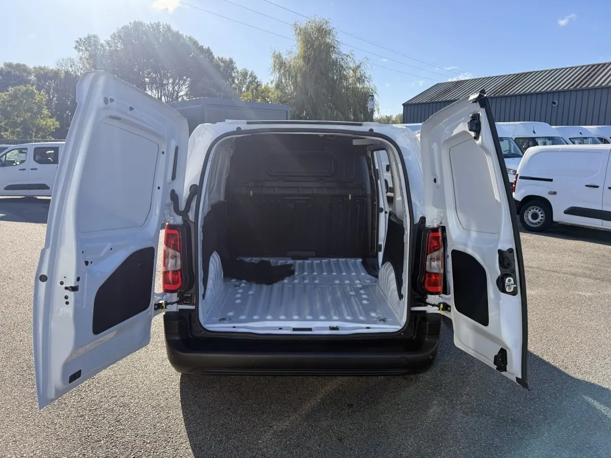 Vue arrière du Peugeot Partner blanc 2026 avec portes battantes ouvertes montrant l’espace de chargement vide.