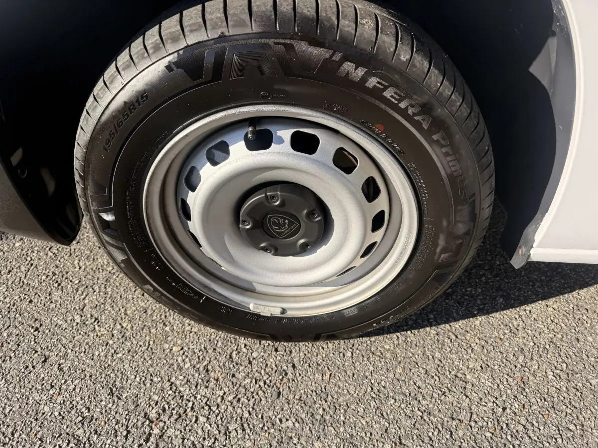 Gros plan sur la roue avant droite du Peugeot Partner blanc 2026 avec jante acier et pneu noir.