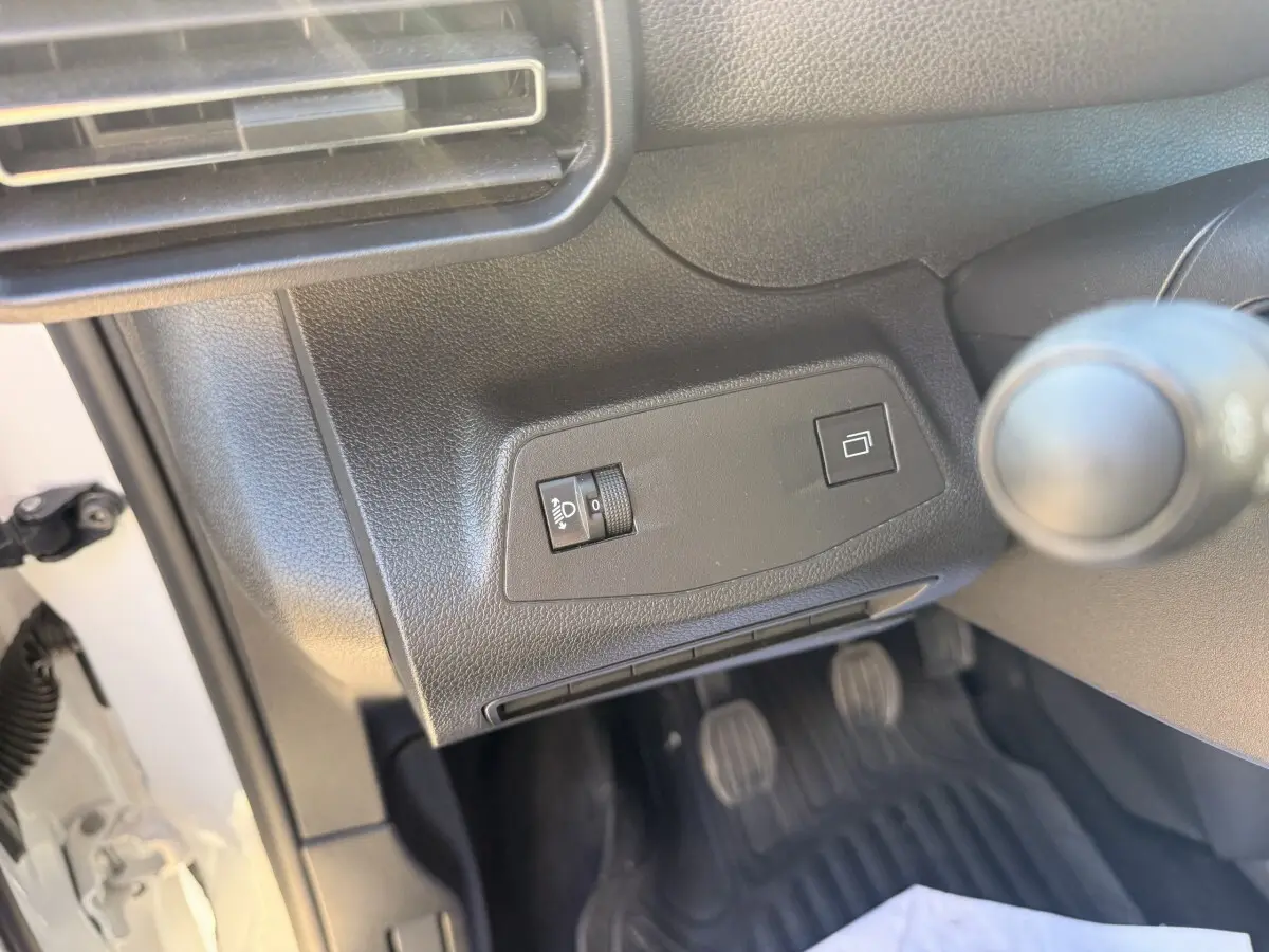 Détail intérieur côté conducteur du Peugeot Partner blanc 2026 montrant les commandes d'éclairage et la boîte manuelle.