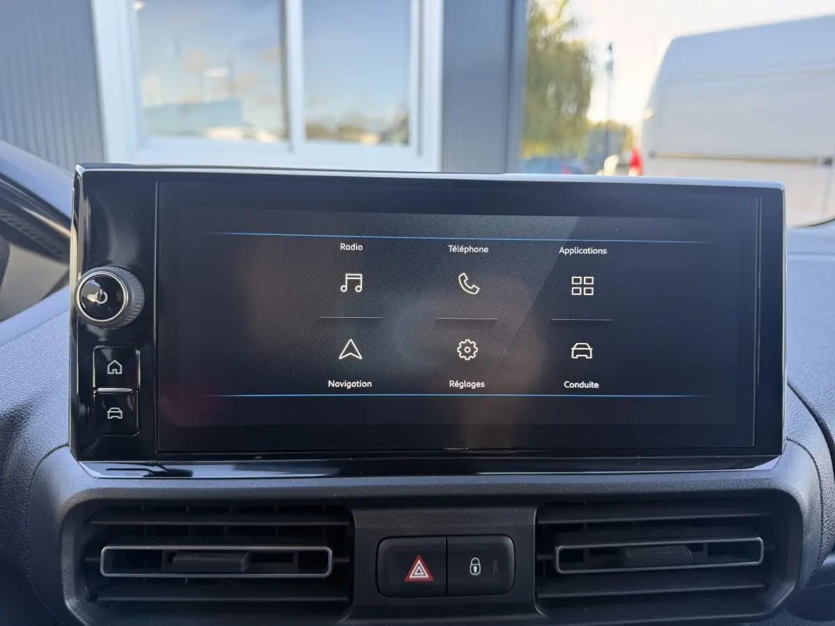 Écran tactile central du tableau de bord du Peugeot Partner 2026, affichant les options radio, téléphone et navigation.