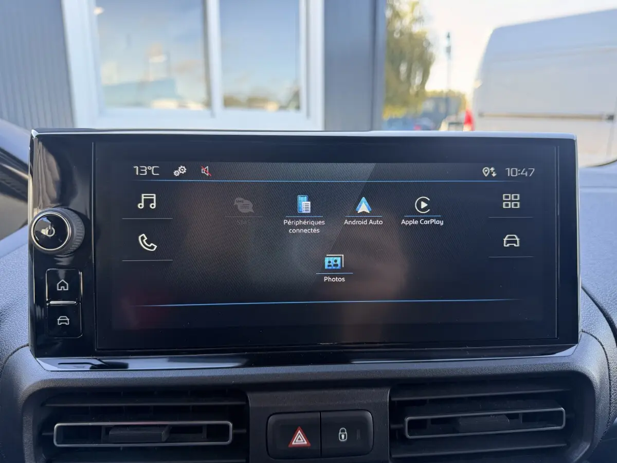 Écran tactile central du Peugeot Partner blanc, vue intérieure frontale avec commandes multimédias affichées.