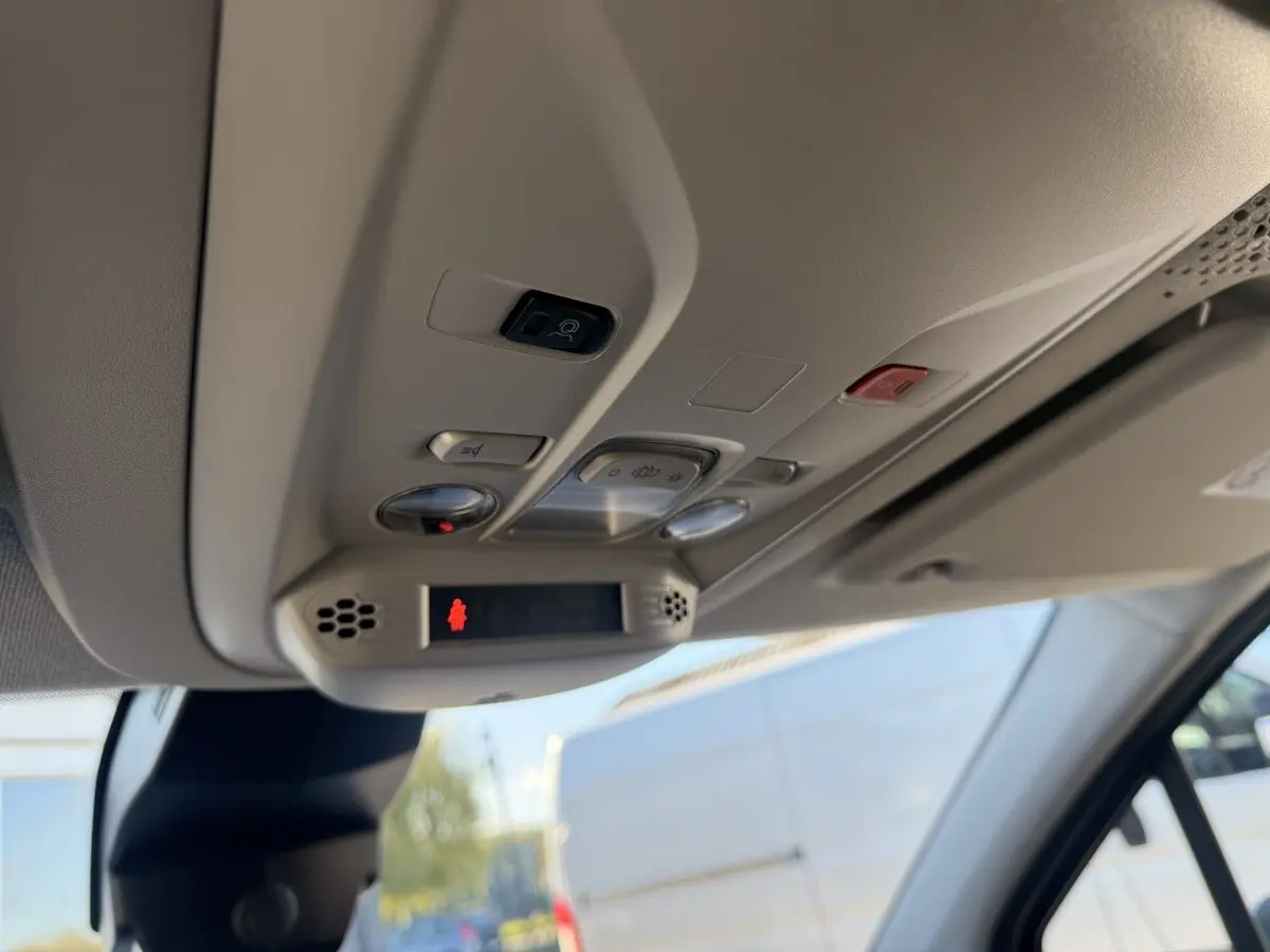 Vue intérieure du plafond avant du Peugeot Partner blanc 2026, montrant les commandes d'éclairage et l'appel d'urgence.