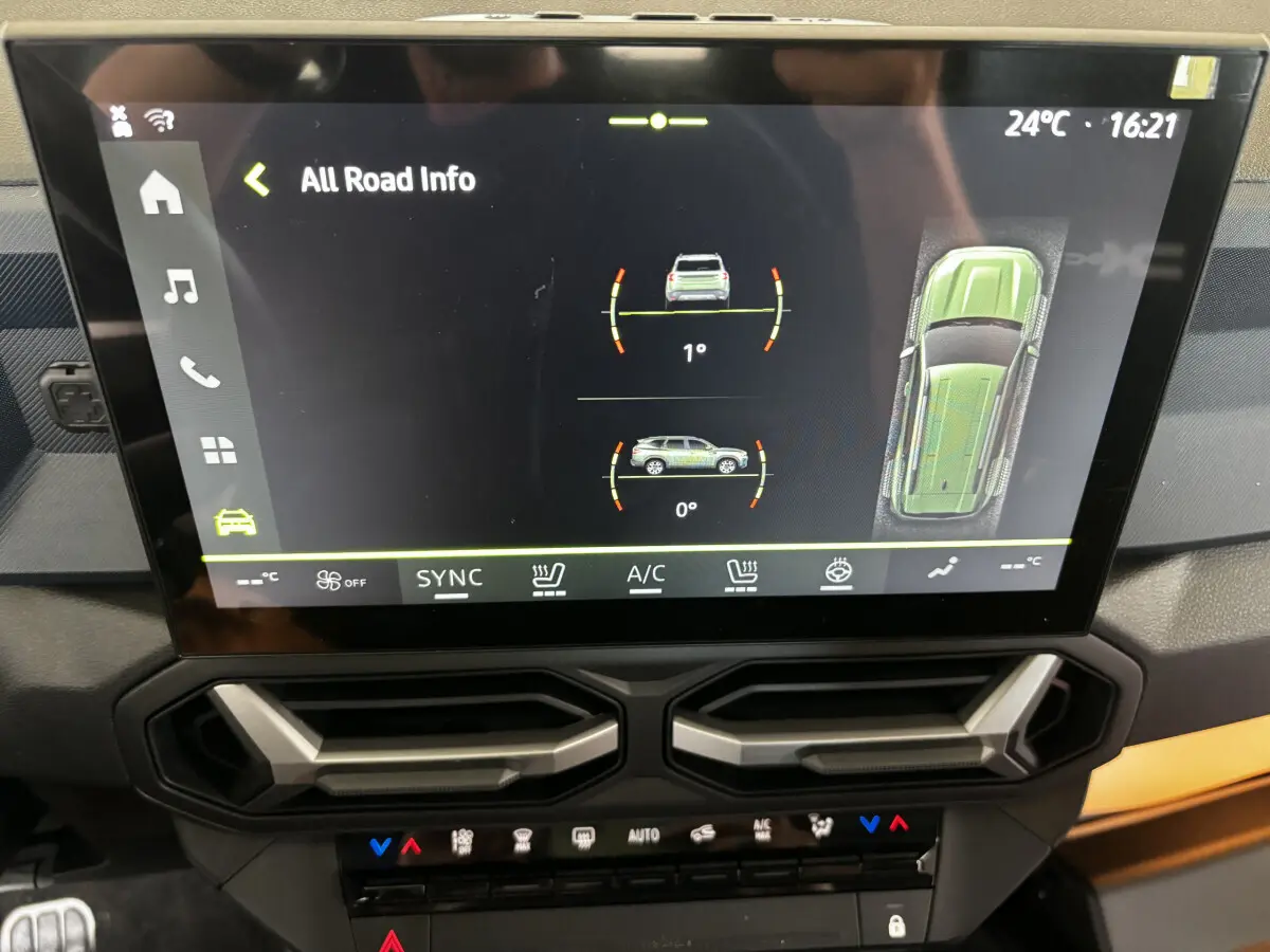 Écran tactile central du tableau de bord du Dacia Bigster gris foncé, affichant les infos tout-terrain et la climatisation.