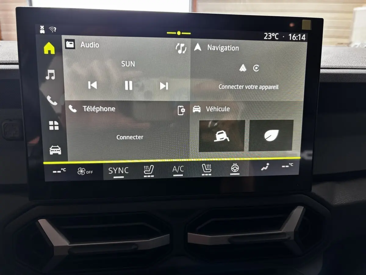 Écran tactile central du tableau de bord du Dacia Bigster gris foncé, affichant les menus audio, navigation et véhicule.