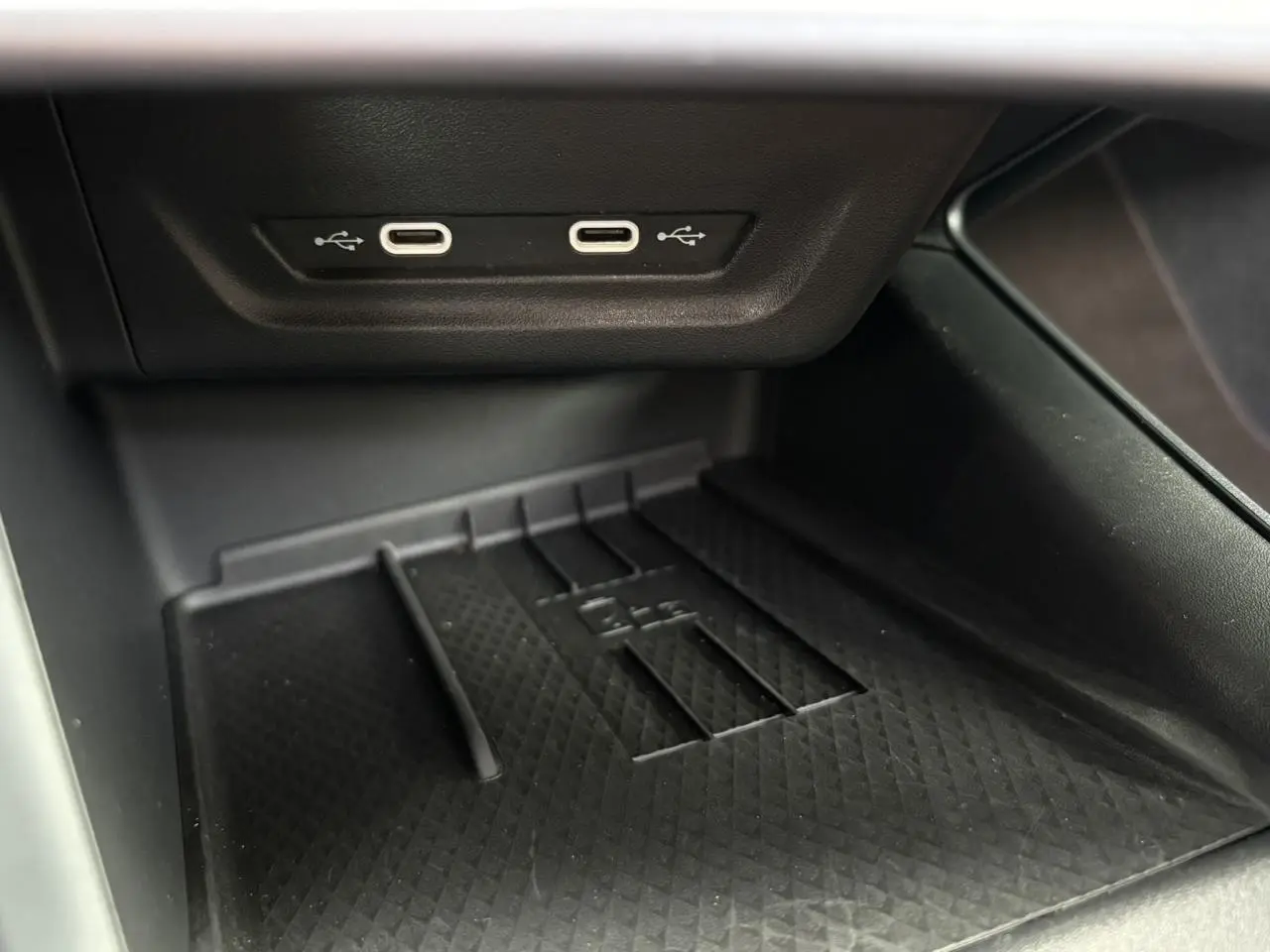 Gros plan sur la console centrale du CUPRA TERRAMAR 2024, montrant deux ports USB-C et un espace de rangement noir texturé.
