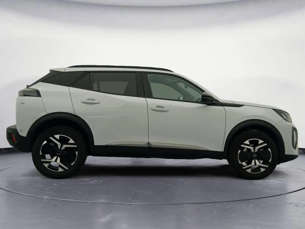 Peugeot 2008 Hybrid blanc vue de profil côté gauche, avec jantes alliage 17 pouces et barres de toit noires.