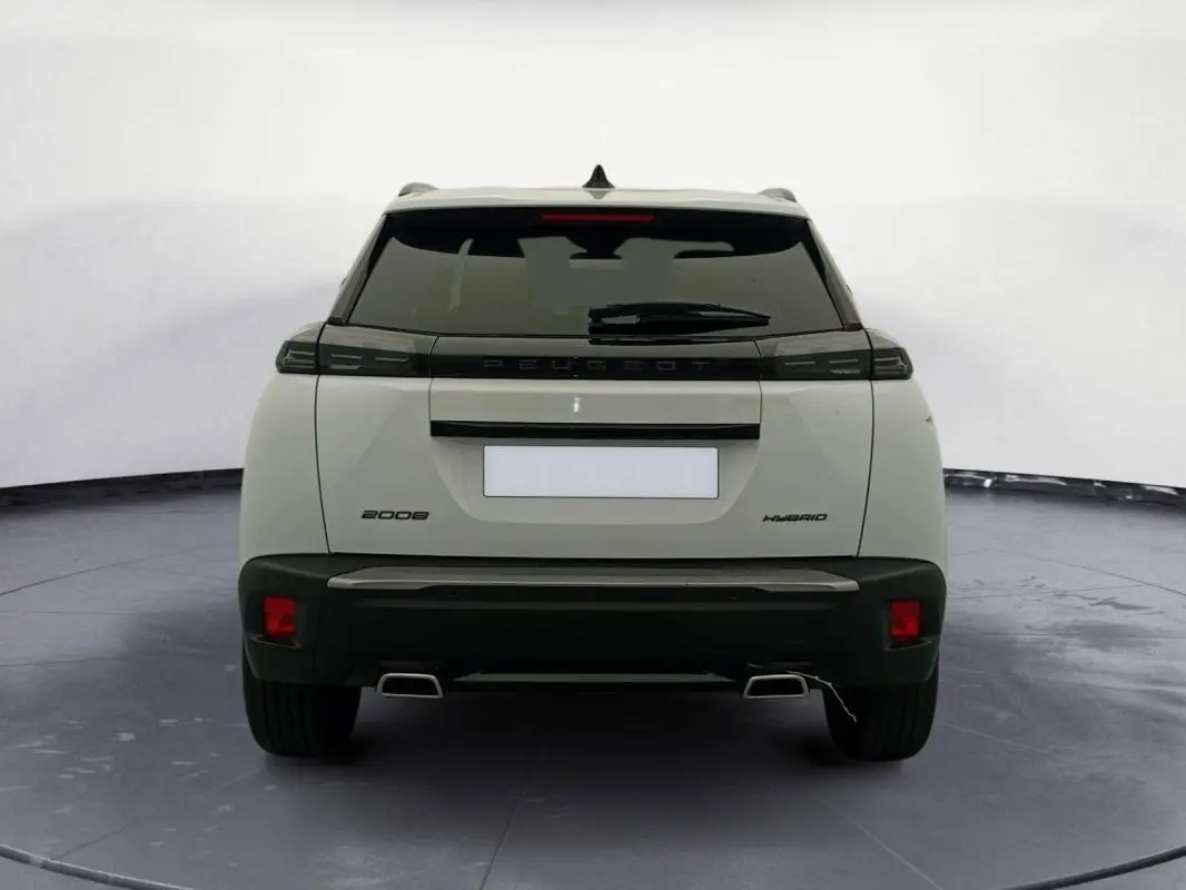 Vue arrière d’un Peugeot 2008 Hybrid blanc avec feux arrière noirs et double sortie d’échappement chromée.
