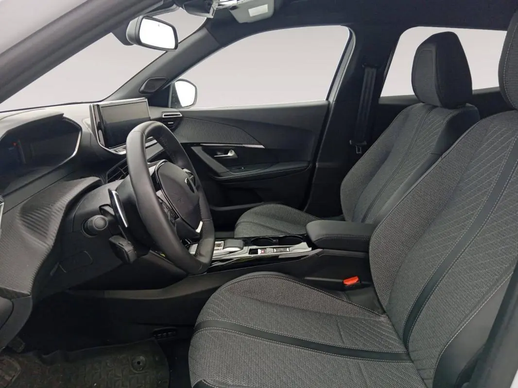 Vue intérieure côté conducteur du Peugeot 2008 Hybrid 136 e-DCS6 Allure 2024, sièges gris et tableau de bord moderne.