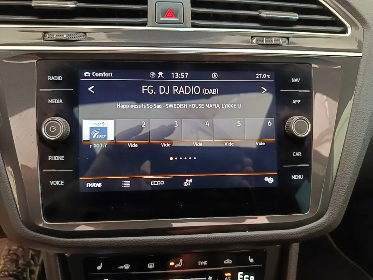 Écran tactile central du Volkswagen Tiguan 1.4 eHybrid 2023 affichant la radio FM/DAB en intérieur noir.