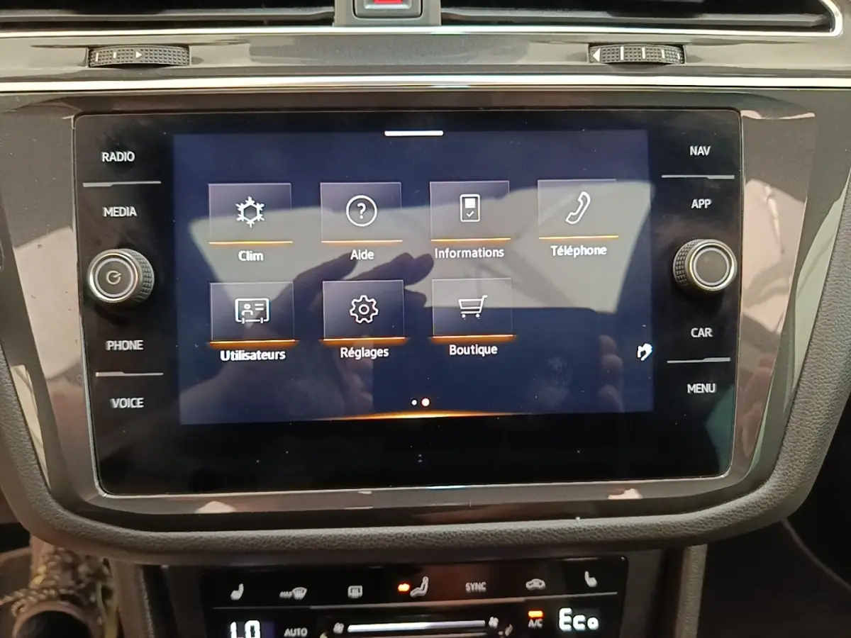 Écran tactile central affichant le menu principal du système multimédia dans un Volkswagen Tiguan blanc 2023.