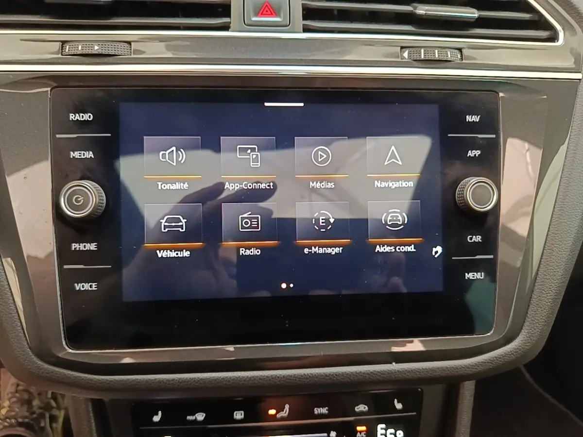 Écran tactile central du Volkswagen Tiguan blanc 2023 affichant le menu multimédia et navigation.