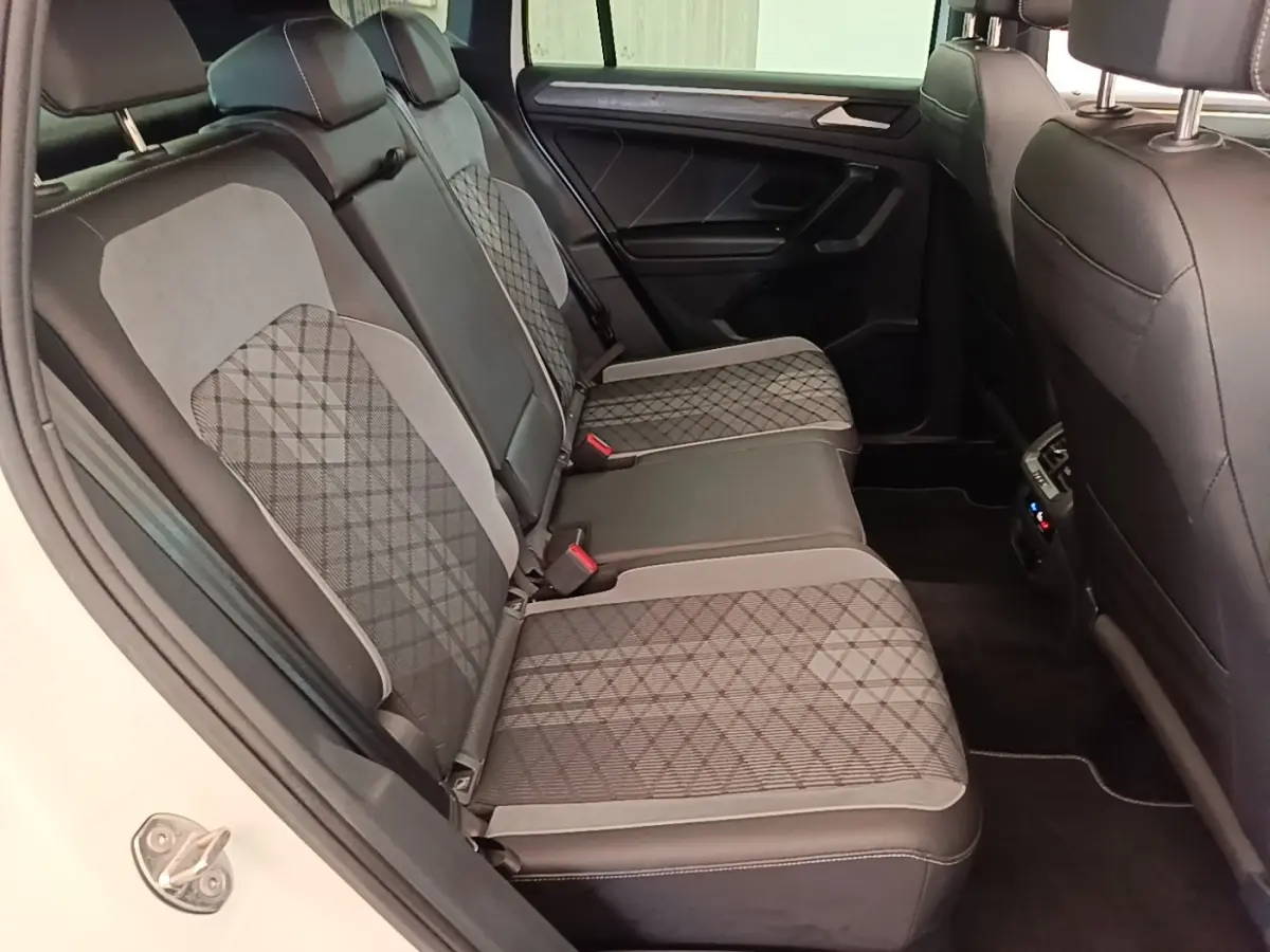 Vue intérieure côté droit des sièges arrière en tissu gris à motifs du Volkswagen Tiguan blanc 2023 hybride rechargeable.
