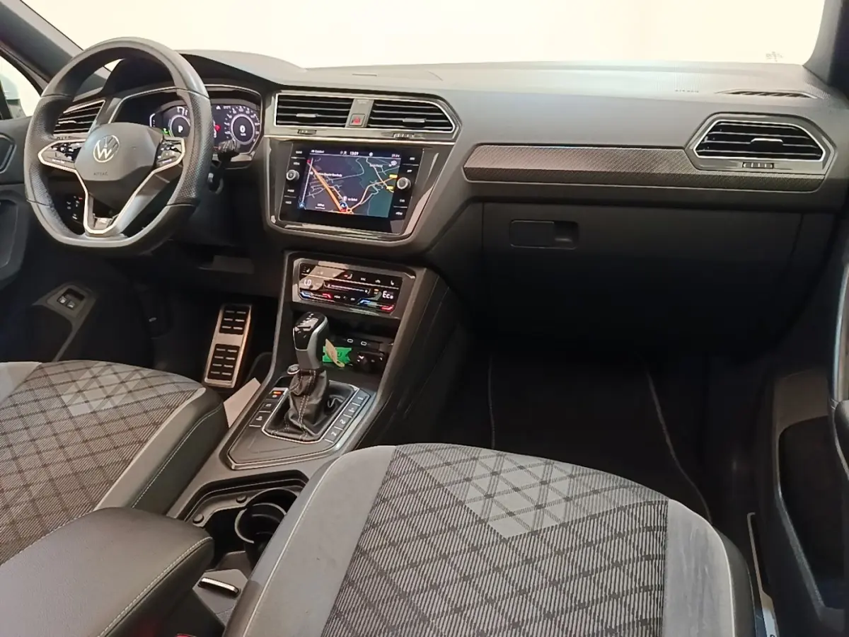 Intérieur avant du Volkswagen Tiguan blanc 2023, vue côté passager, tableau de bord avec écran tactile et volant multifonctions.