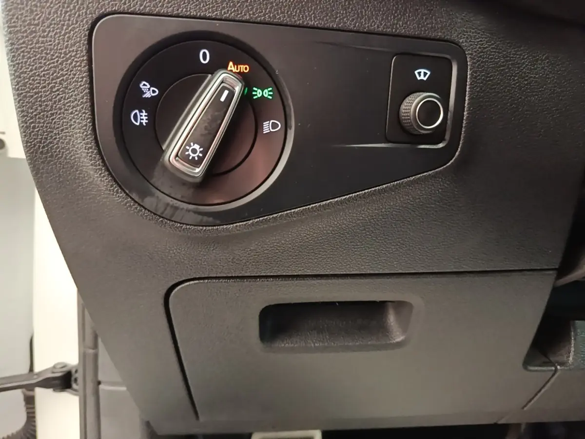 Gros plan sur le sélecteur de phares et le bouton de réglage des essuie-glaces du Volkswagen Tiguan blanc 2023.
