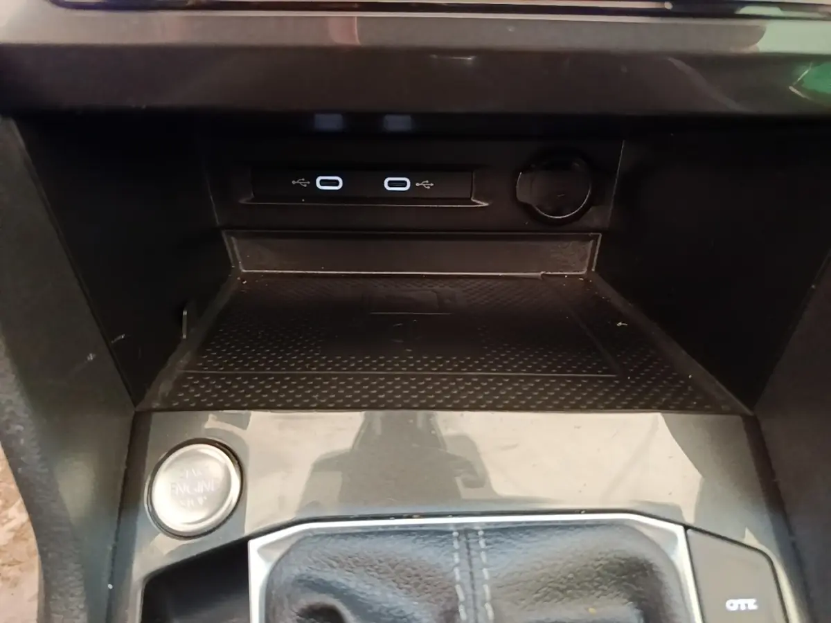 Gros plan sur la console centrale du Volkswagen Tiguan blanc 2023, avec bouton démarrage et ports USB visibles.