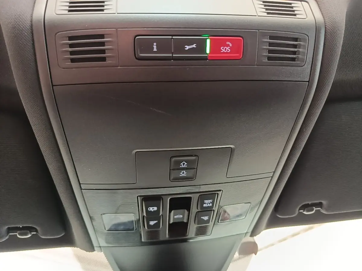 Vue intérieure du plafonnier avec commandes d’éclairage et bouton SOS du Volkswagen Tiguan blanc 2023 hybride rechargeable.