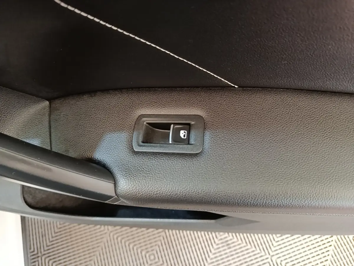 Détail de la poignée intérieure de coffre noir du Volkswagen Tiguan blanc 2023, version hybride rechargeable R-Line.