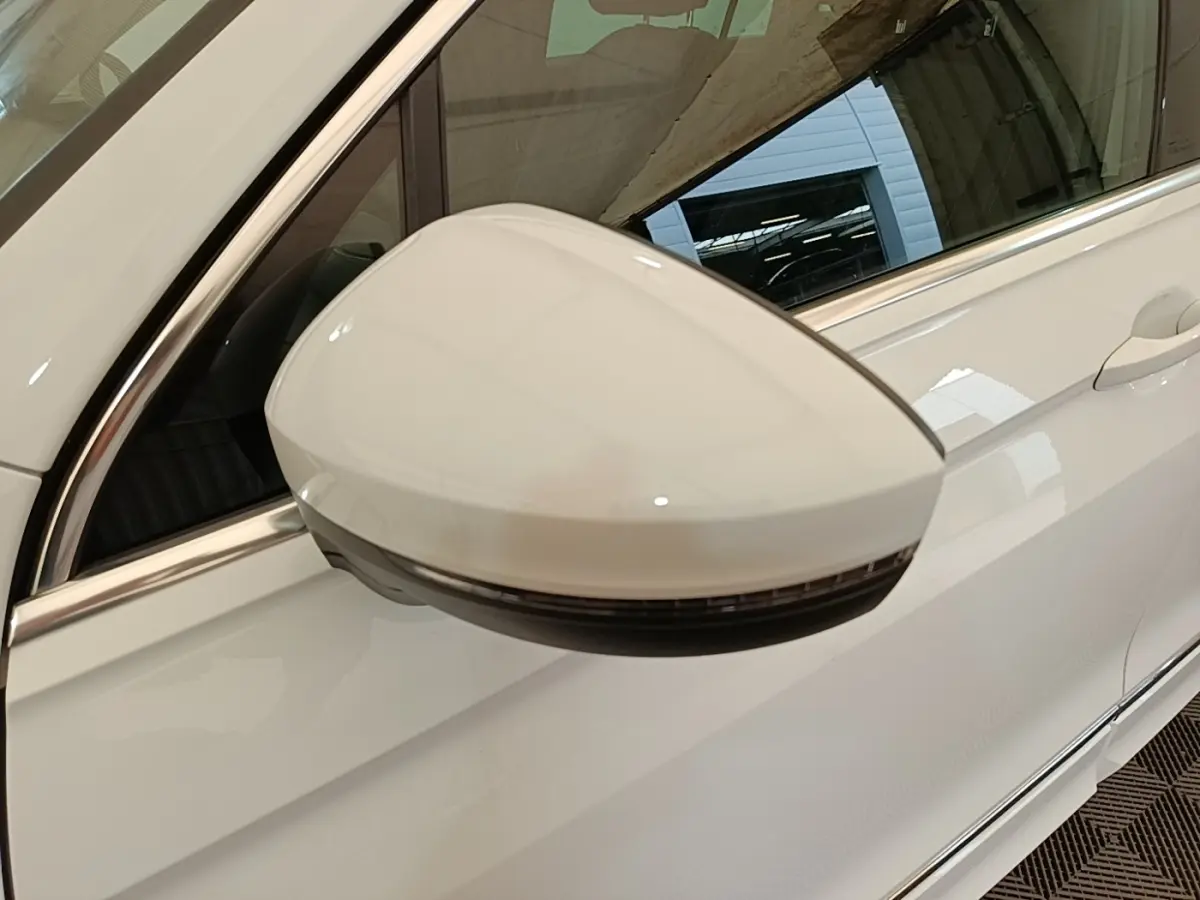 Rétroviseur électrique blanc côté conducteur du Volkswagen Tiguan 1.4 eHybrid 2023, vue rapprochée sur porte blanche.