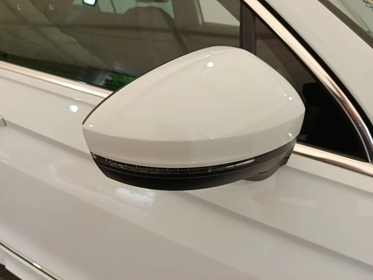 Rétroviseur électrique blanc côté gauche du Volkswagen Tiguan 1.4 eHybrid 2023 avec clignotant intégré.