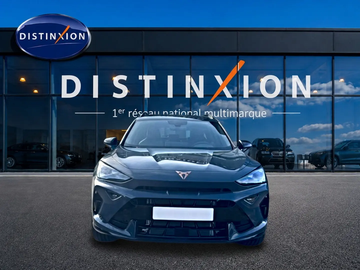Vue avant d'un CUPRA Formentor bleu fjord garé devant une vitrine avec logo Distinxion.