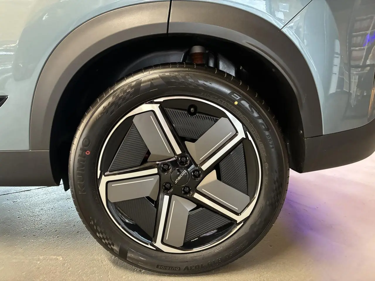 Gros plan sur la roue avant gauche du SUV JAECOO J7 gris olive, avec jante alliage noire et grise au design moderne.