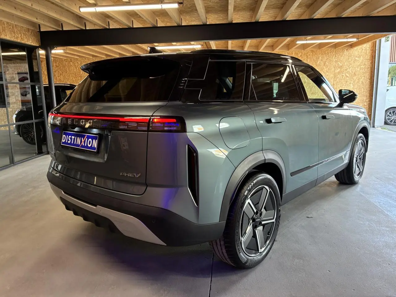 Vue 3/4 arrière droit du SUV JAECOO J7 gris olive avec toit noir et feux arrière LED continus.