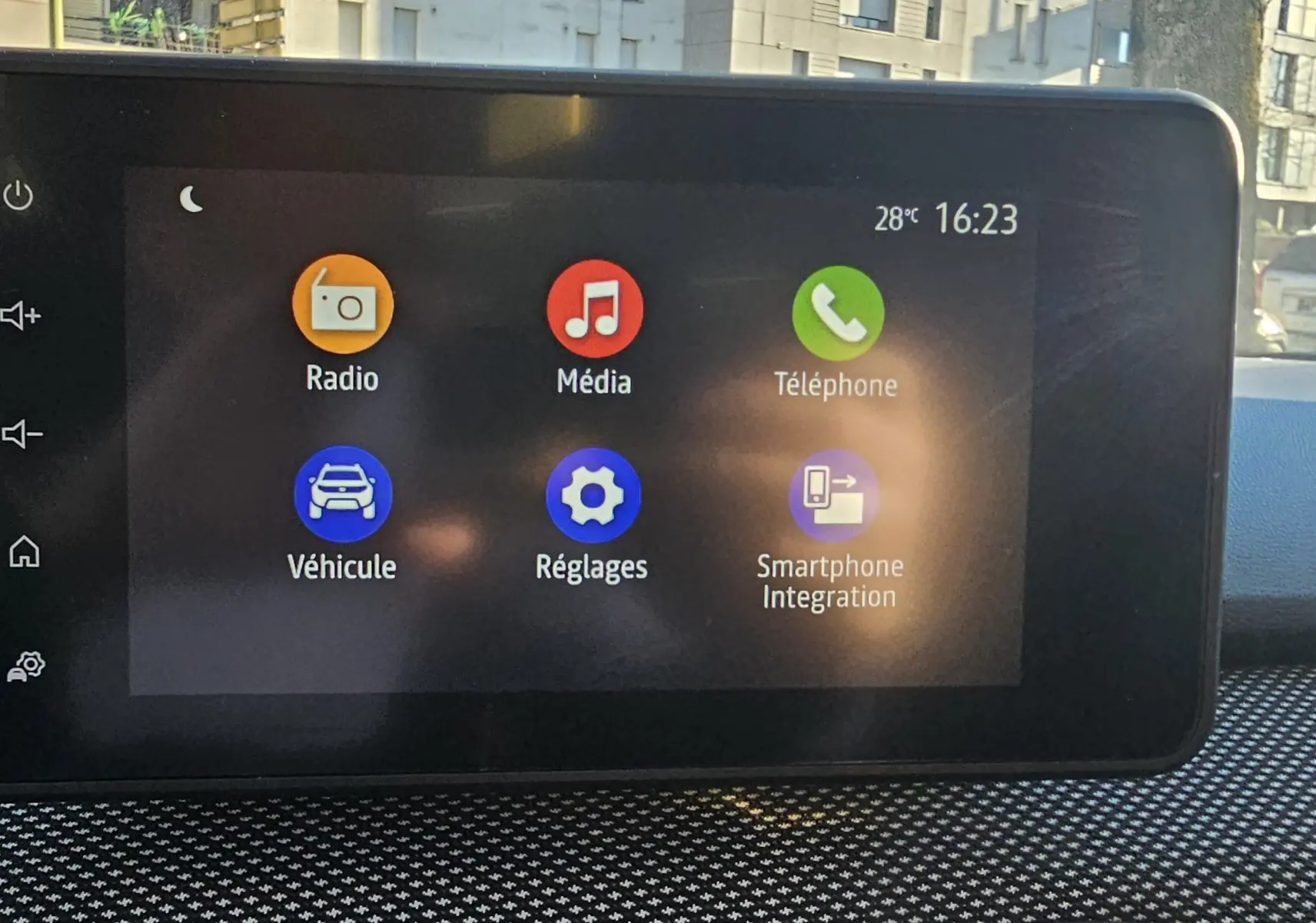 Écran tactile central de la Dacia Sandero III 2022 affichant les icônes Radio, Média, Téléphone, Véhicule, Réglages et Smartphone Integration.