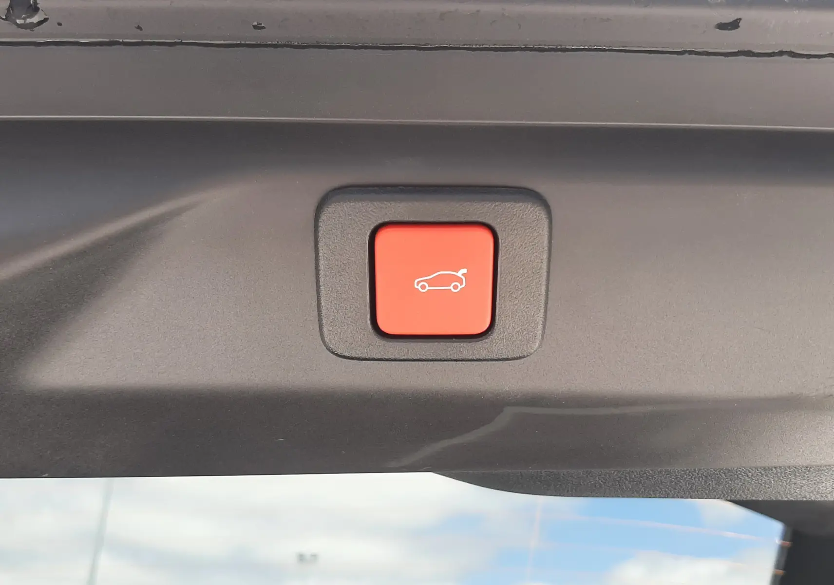 Bouton rouge de fermeture électrique du hayon sur Peugeot 3008 1.2 Hybrid 145ch GT bleu Obsession, vue intérieure du coffre.