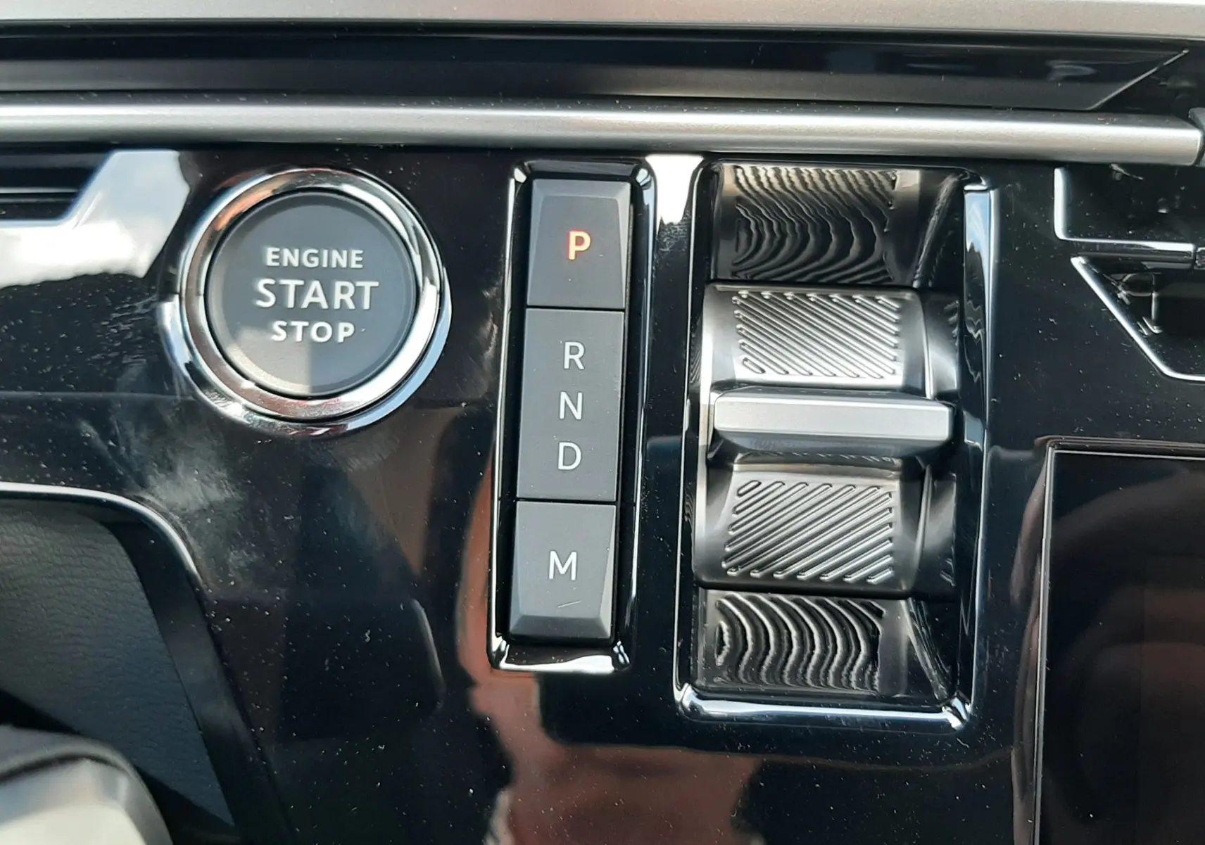 Gros plan sur la console centrale du Peugeot 3008 1.2 Hybrid 145ch GT 2026, avec bouton start/stop et commande de boîte auto.