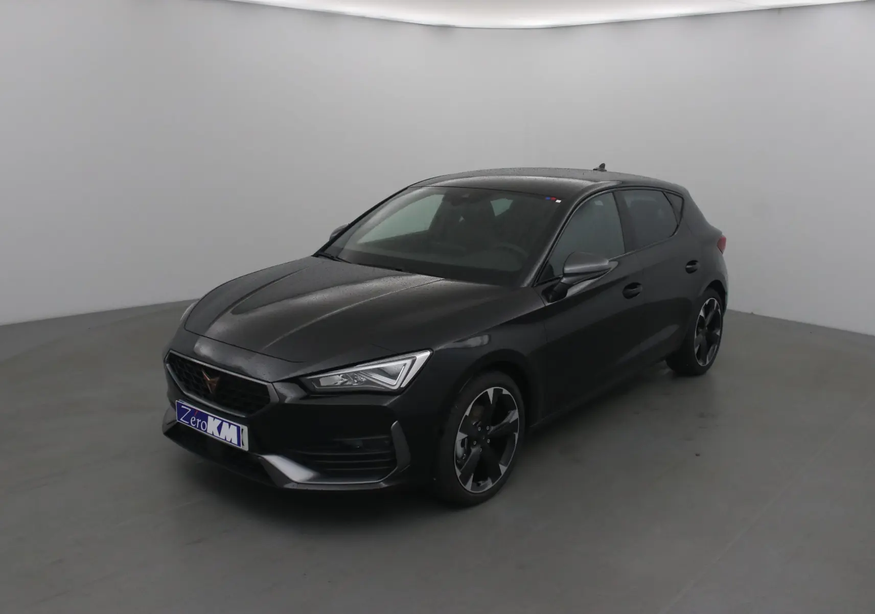 Vue 3/4 avant droite d'une CUPRA Leon noire 2023 avec jantes bi-ton et phares LED distinctifs.