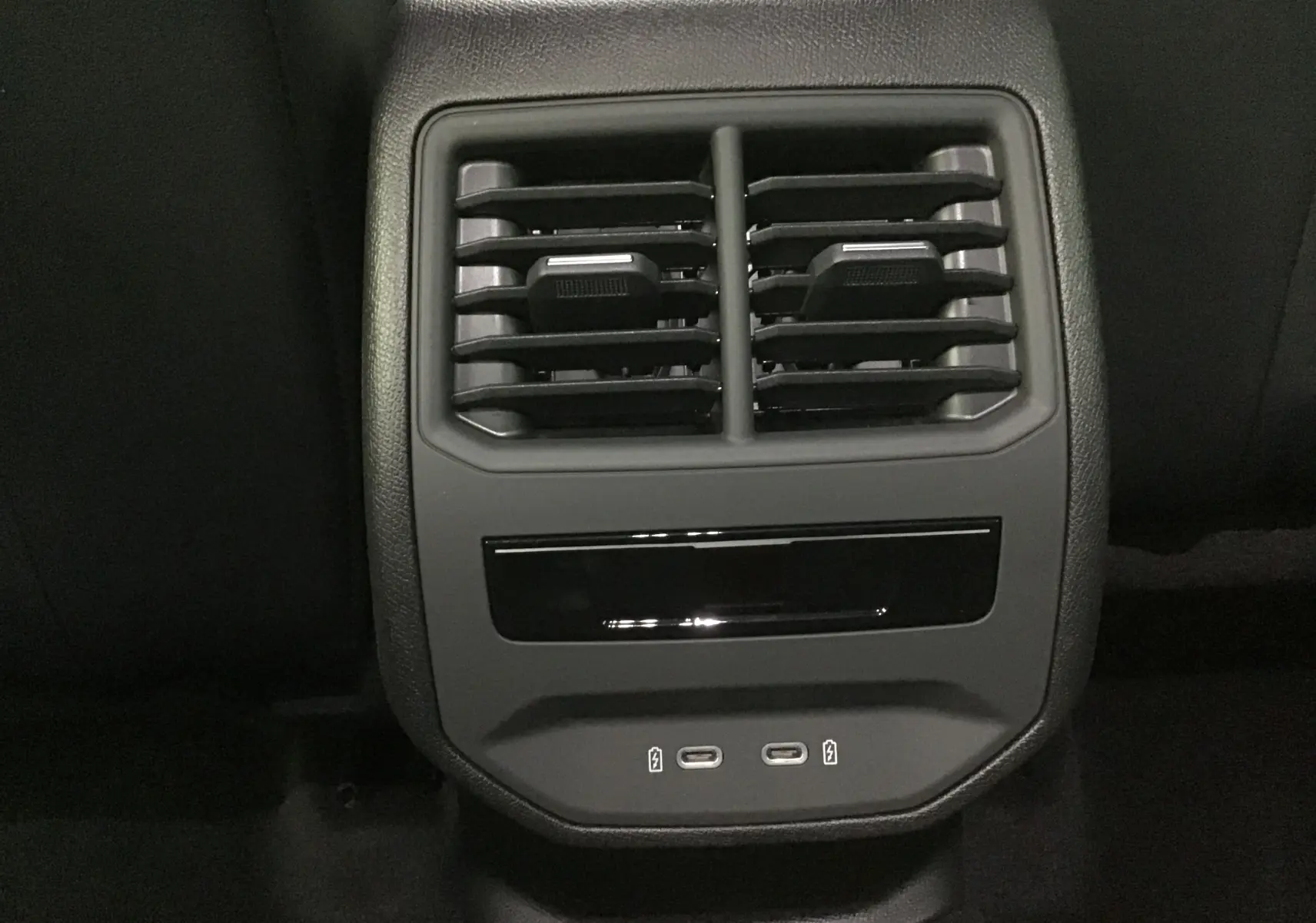 Gros plan sur les aérateurs arrière et les ports USB-C du système de climatisation d'une CUPRA Leon noire 2023.