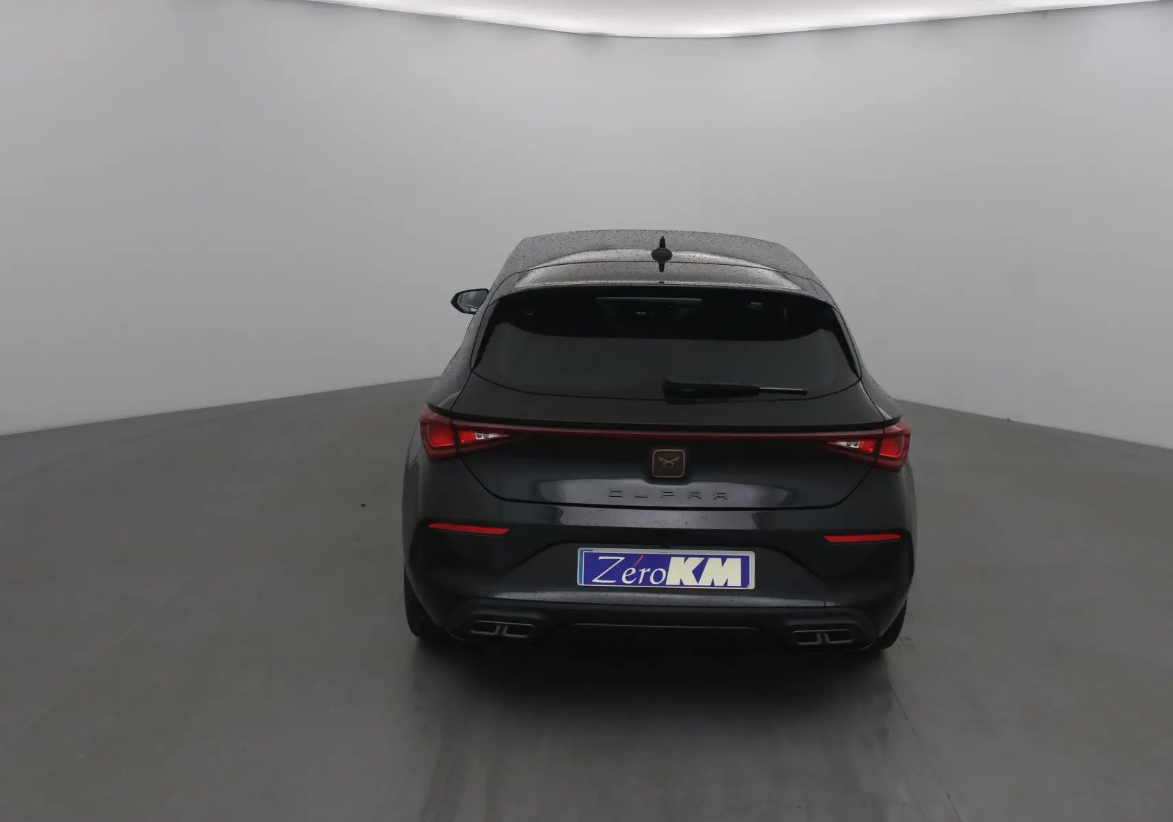 Vue arrière d'une CUPRA Leon noire 2023 avec feux LED reliés et double sortie d'échappement intégrée au pare-chocs.