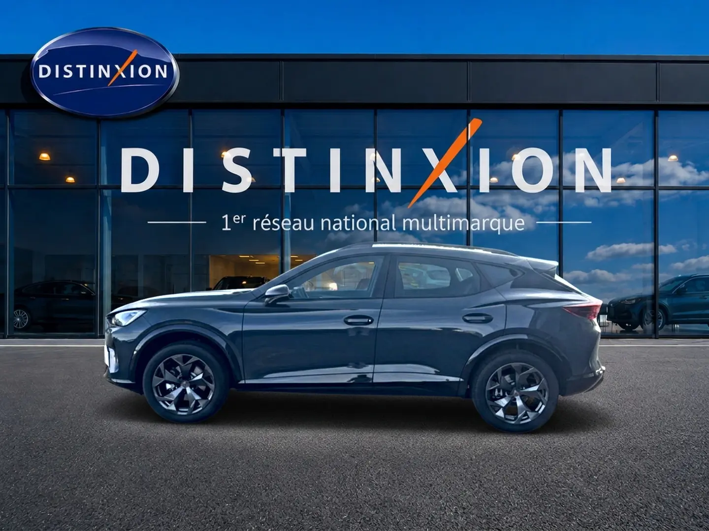 Vue de profil côté gauche d'un CUPRA Formentor bleu fjord 2026 garé devant une vitrine Distinxion.