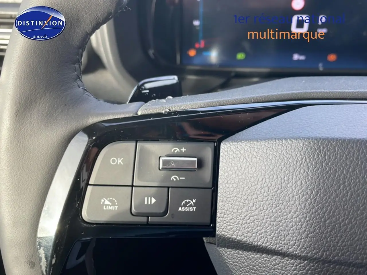 Gros plan sur les commandes multifonctions à gauche du volant cuir du Citroën Berlingo gris Artense 2025.