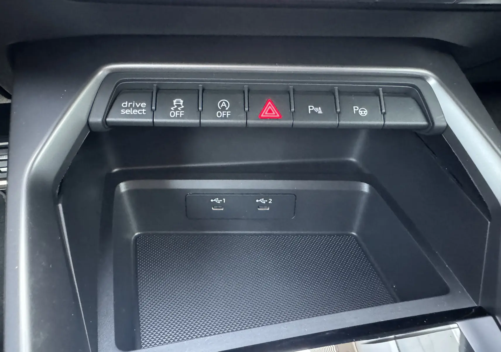 Vue rapprochée de la console centrale noire de l'Audi A3 Sportback TDI 2.0 S-Line 2023 avec boutons de contrôle et ports USB.