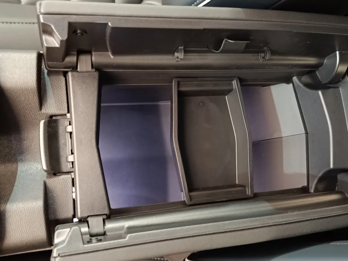 Vue rapprochée de l'intérieur du coffre à gants noir du Citroën C5 Hybride 2026, avec compartiment amovible.
