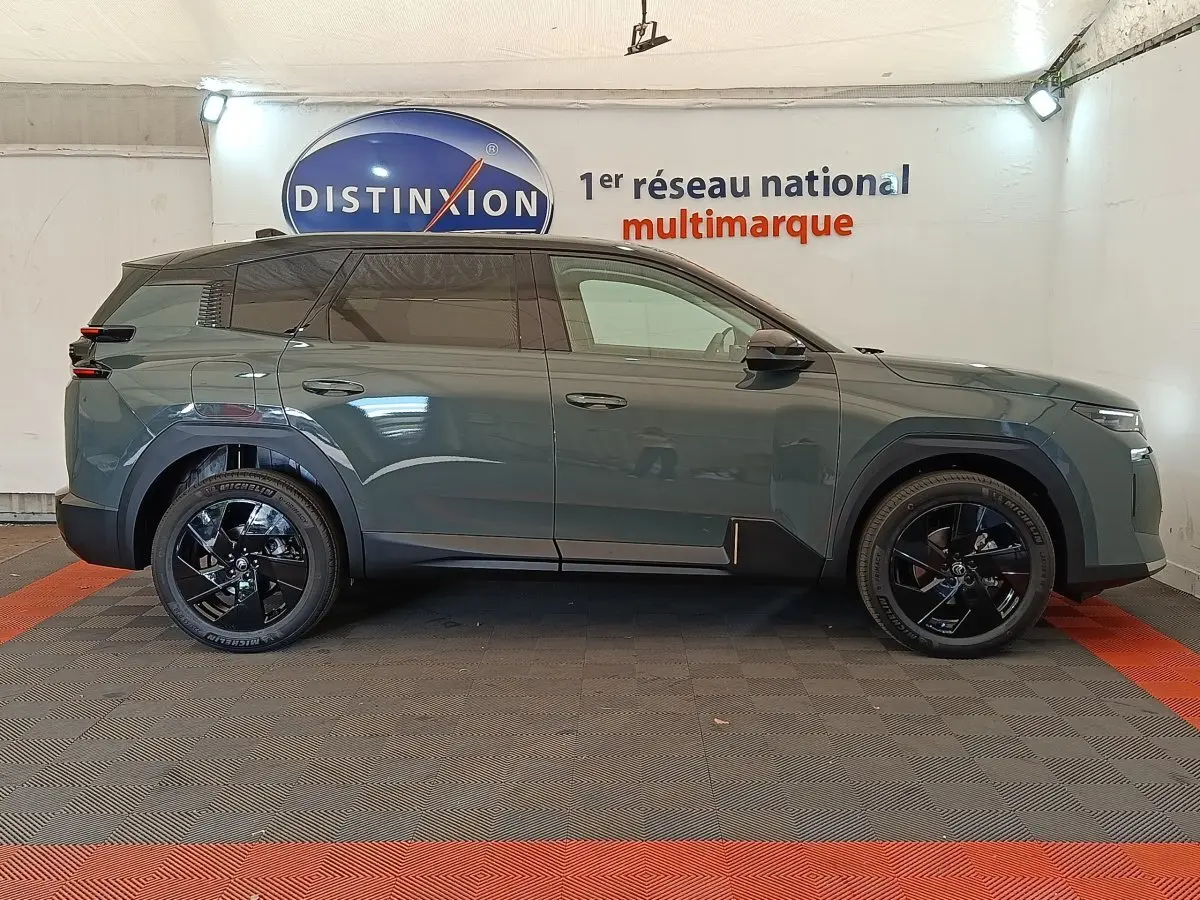 Vue de profil côté gauche d'une Citroën C5 hybride 145ch auto MAX vert avec jantes noires et vitres teintées.