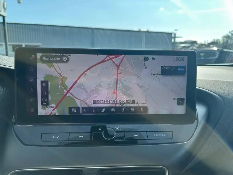 Écran tactile central du Nissan Juke 2025 affichant une carte de navigation avec commandes audio en dessous.
